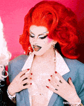 a drag queen with red hair and red nails