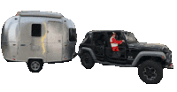 a man in a santa suit is driving a jeep behind a trailer