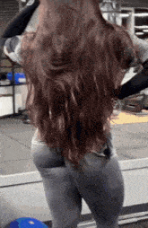 a woman with very long hair is standing in front of a mirror