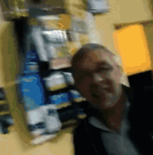 a blurry picture of a man standing in front of a shelf full of boxes