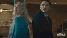 a man and a woman are standing next to each other with a fantastic 4 logo in the background