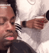 a man with a cup in his hand and the words igo live behind him