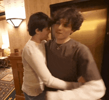 a man and a woman are hugging in front of a door
