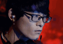 a close up of a man wearing glasses and earbuds