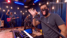 a man wearing a mask singing into a microphone