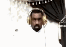 a man with a beard is wearing headphones and making a face .
