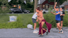 a woman in a red dress is running down a road