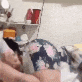 a woman in a floral dress is laying on a bed with her back to the camera .