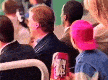 a person in a pink hat is holding a bag of mrs. crisps