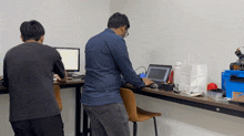 a man sitting at a desk working on a laptop computer