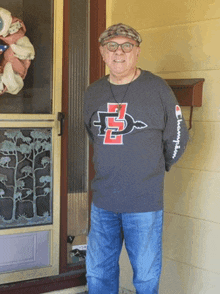 a man standing in front of a door wearing a champion shirt