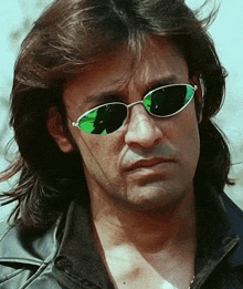 a man with long hair wears sunglasses and a black jacket