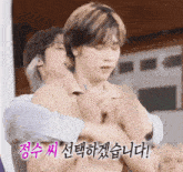 a man is hugging another man with korean writing on the bottom right