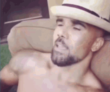 a shirtless man with a beard wearing a white hat