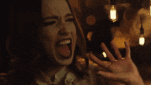 a close up of a woman making a funny face with her hand