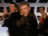 a group of young men are standing next to each other and dancing in a room .
