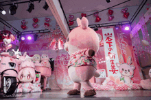a pink stuffed animal is standing in front of a sign that says ' strawberry '