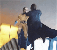a man in a superhero costume is standing next to another man in a black cape