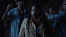 a man and a woman are dancing in a dark room with smoke coming out of it .