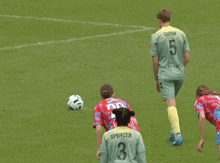 a soccer player with the number 3 on his back kicks the ball