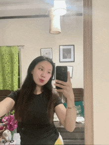 a woman is taking a selfie in front of a mirror with her phone