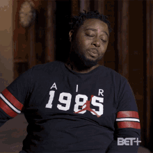 a man is wearing a black shirt that says 1985