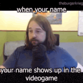 a man with long hair and a beard is wearing a pair of black socks while sitting in a chair .