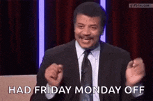 a man in a suit and tie is saying `` had friday monday off '' while sitting on a stage .
