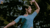 a woman in a blue saree is dancing with a man in a red shirt .