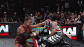 two wrestlers are fighting in front of a crowd with a sign that says n on it