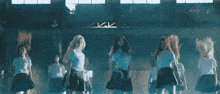a group of young women are dancing in a dark room .