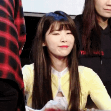 a woman with long hair is sitting in front of a crowd of people .