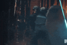a man is holding a sword in a dark room .