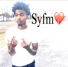 a young man stands in front of a sign that says syfm on it
