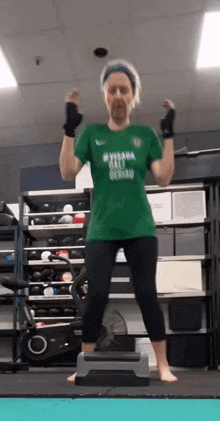 a woman is jumping on a stepper in a gym .