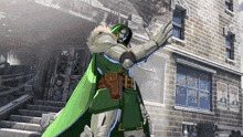 a man in a green cape is standing in front of a brick building with a sign that says ' wanted '