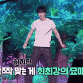 a man in a white shirt is holding a microphone and dancing on a stage in front of a screen with chinese writing