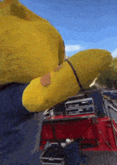 a man in a blue shirt is wearing a yellow spongebob costume