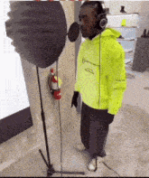 a man in a neon yellow hoodie is standing in front of a microphone .