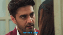 a man and a woman are looking at each other and the words we are over are on the bottom of the screen .