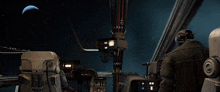 a man sitting in the cockpit of a space ship looking at a space ship