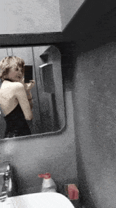 a woman takes a selfie in a bathroom mirror
