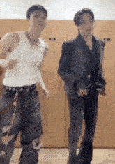 two men are dancing in a locker room in front of wooden lockers .