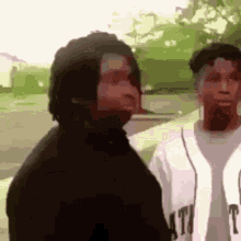 a man and woman are standing next to each other on a sidewalk .