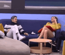 a man and a woman are sitting on a blue couch