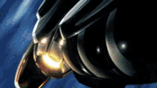 a close up of a black object with a yellow light on it