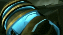a close up of a blue and gold object with a glowing light coming out of it .