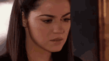 a close up of a woman 's face with a sad look on her face