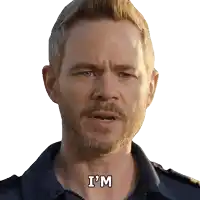 a man with a beard says " i 'm " in front of a white background