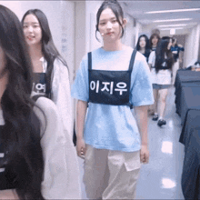 a girl wearing a blue shirt and a black vest with chinese writing on it